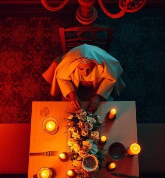 Draufsichtbild einer Person in Tracht, die an einem Tisch voller Essen und Kerzen speist. Das Bild hat eine Atmosphäre mit einem roten und blauen Ton