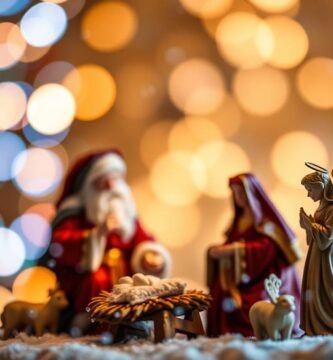 Abbildung in kleinen Puppen einer selbstgemachten Weihnachtskrippe von Maria neben den Engeln in der Krippe neben einer kleinen Weihnachtsmannpuppe.